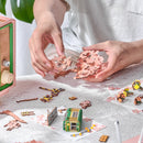 Een persoon bouwt de Robotime Sakura Dreamy Tour