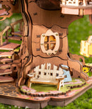 Close-up van het bankje en raampje aan de onderkant van de Robotime Sakura Tree House