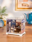 Sfeervolle presentatie van de Robotime Butter Bakery House, kunststof miniatuur bakkerijtje in een kleine display case