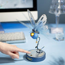 Een persoon gebruikt de touchknop van de Robotime Butterfly (Blue) om de vleugels te laten bewegen