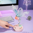 Een persoon gebruikt de touchknop om de vleugels van de Robotime Butterfly (Pink) te laten bewegen