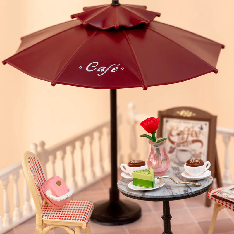 Details van de parasol, tafel en een stoel van de Robotime Chic Café Terrace