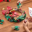 Een persoon is bezig de Robotime Christmas Wreath te knutselen