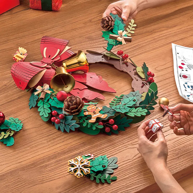 Een persoon is bezig de Robotime Christmas Wreath te knutselen