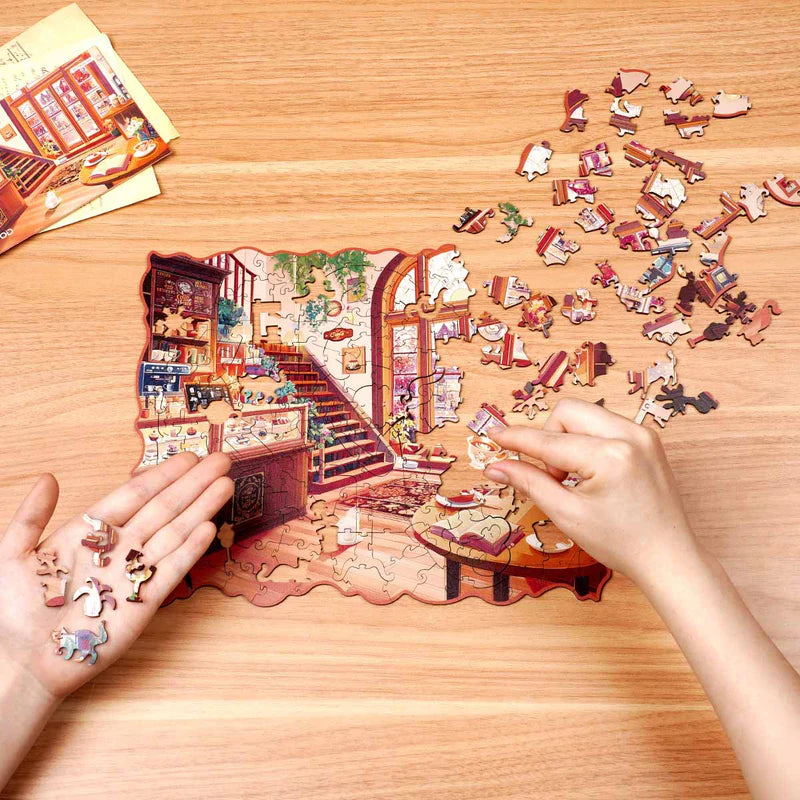 Een persoon is bezig de Robotime Cozy Winter Café legpuzzel te maken