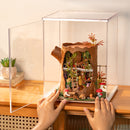 De Robotime Fairytale Tree House in de Robotime Dust Cover Portrait L, met demonstratie van het openslaande deurtje