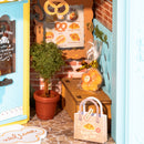 Ingepakt cakeje, een plant, tasje en bord met menukaart in de Robotime Fluffy Cat Bakery