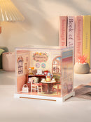 Sfeervolle presentatie van de Robotime Honey Tea Lounge, kunststof miniatuur theesalon in een kleine display case