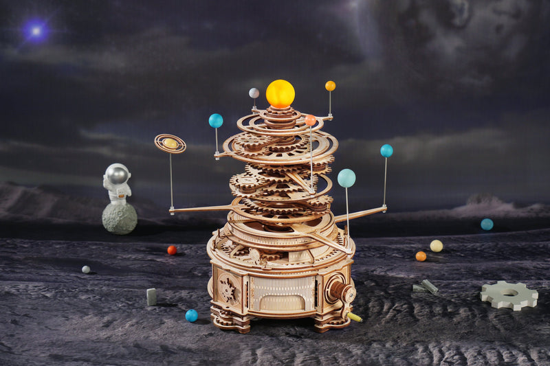 De Robotime Mechanical Orrery met decoratie eromheen en een maandlandschap op de achtergrond