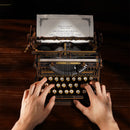 Een persoon typt een brief op de  Robotime Mechanical Typewriter (Classic Version)