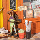 Paraplubak, welkomstbord, plant en kranten bij de ingang van de Robotime Old Time Bookstore