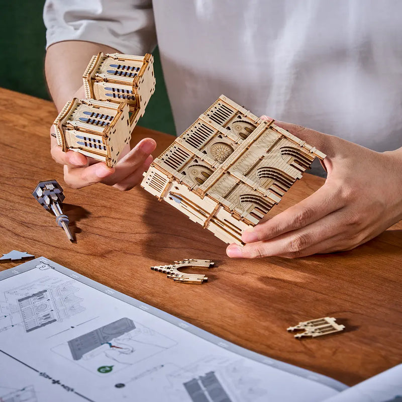 Een persoon is bezig de Robotime Paris Cathedral te bouwen