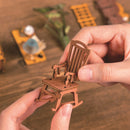 Een persoon die het schommelstoeltje van de Robotime Silent Corner Study in elkaar zet