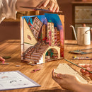 Twee personen zijn de Robotime Street Scene book nook aan het bouwen