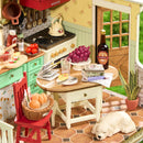 Tafel vol met eten, drinken en andere spullen in het interieur van de Robotime Sunlit Farmhouse Kitchen