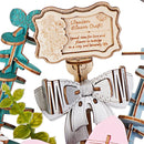 Close-up van het decoratieve bordje met strik in de Robotime Wooden Flower Basket