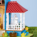 Moomintroll zit buiten op de veranda van het Rolife Moominhouse