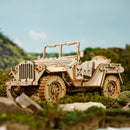 Zijaanzicht van de Robotime Army Field Car in een groene, rotsachtige omgeving