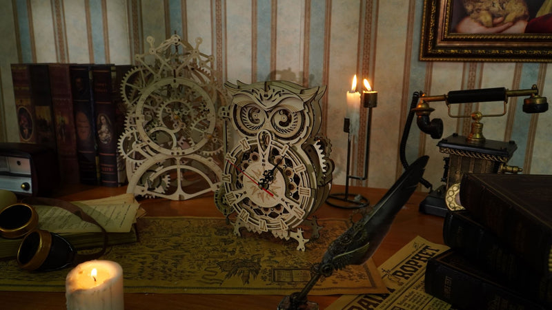 De Robotime Owl Clock en Pendulum Clock in een donkere kamer met brandende kaarsen en vintage deco